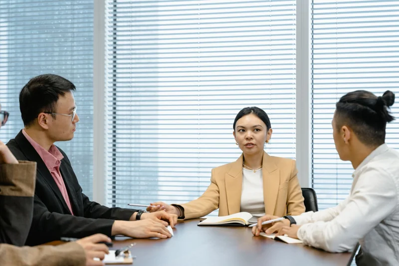 Illustrative photograph of a small group discussing a question around a table.