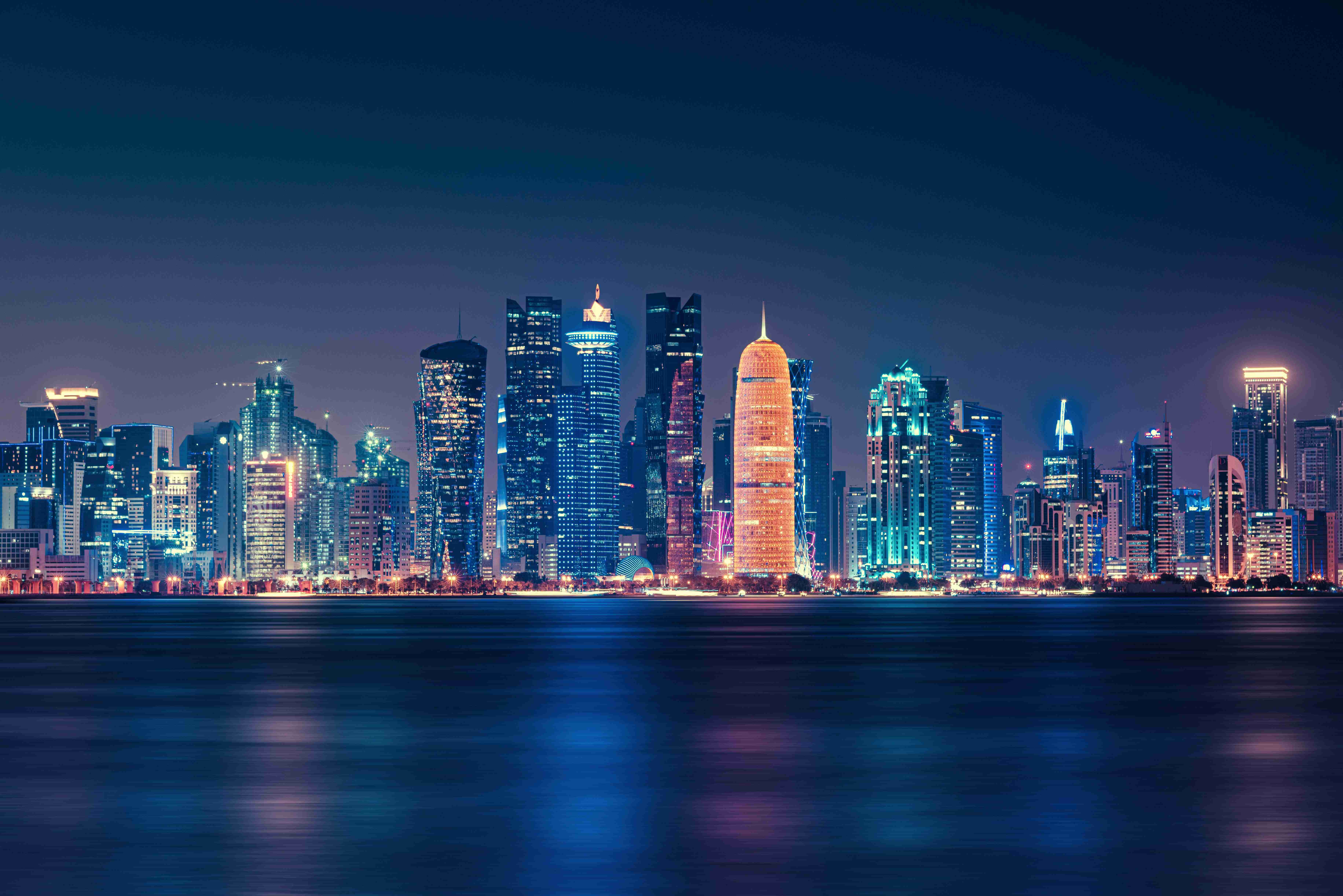 A city skyline lit at night — Real Estate