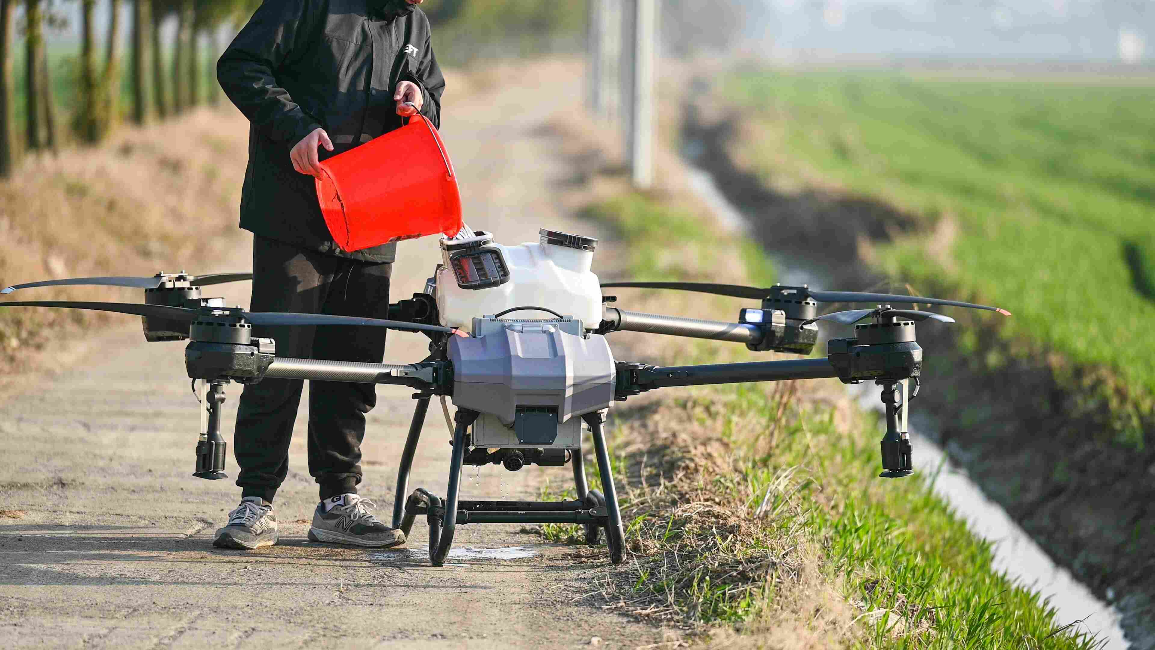 An agricultural spraying drone at the edge of a field — AgriTech