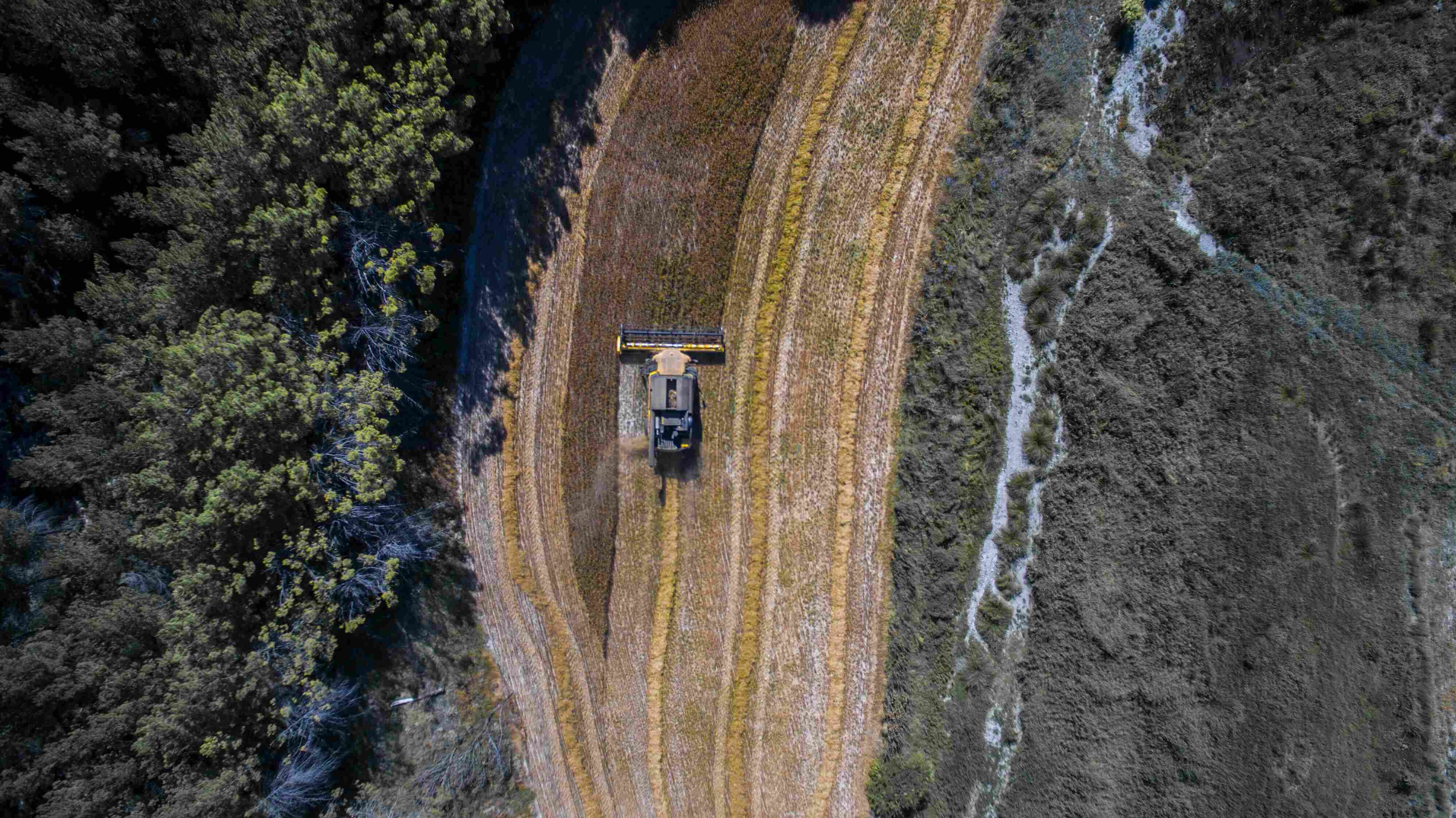 An aerial view of a tractor working between fields — AgriTech