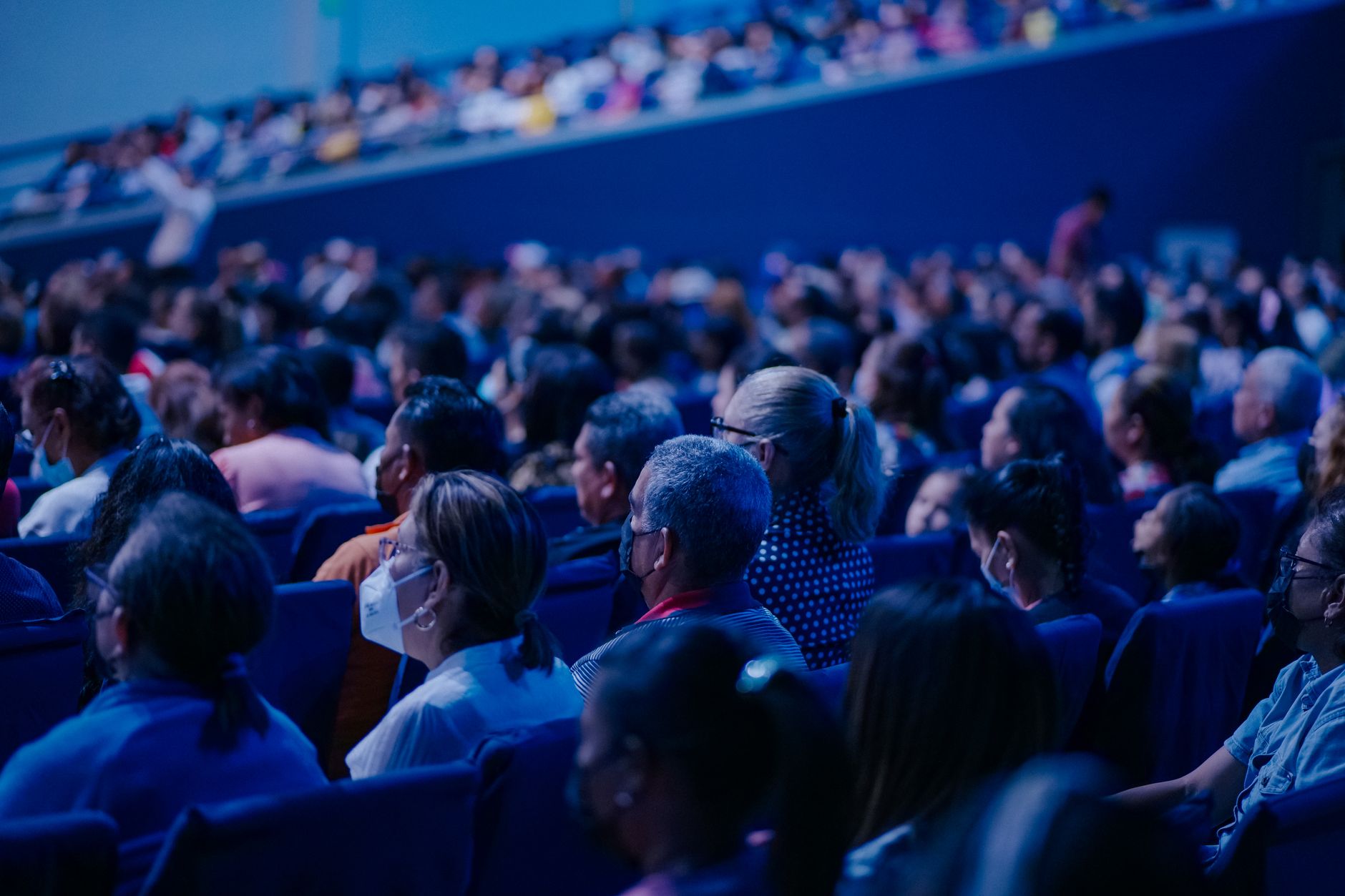 Diverse audience sitting in rows, attending an indoor conference or event — Precision Medicine & Genomics