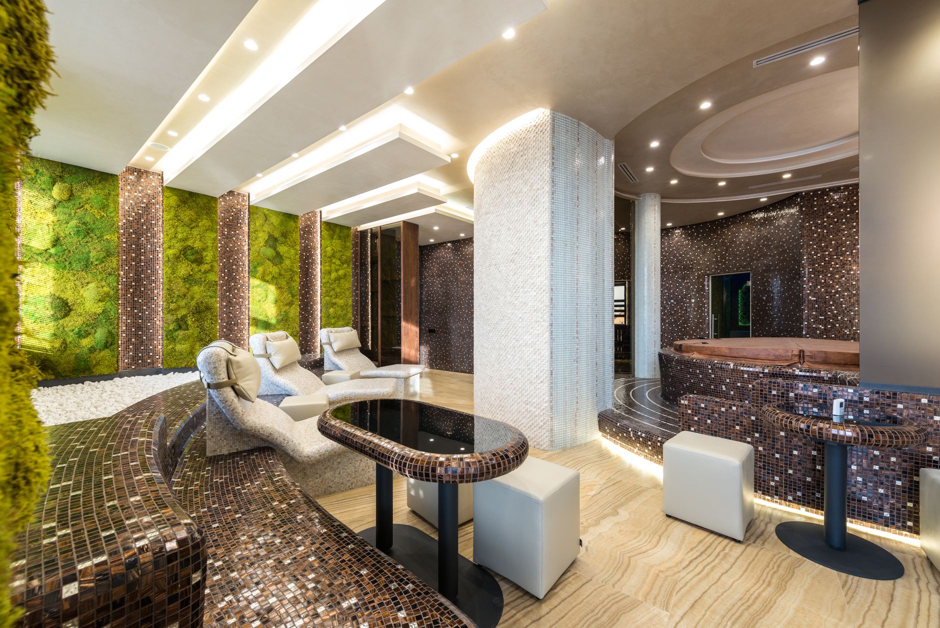 Chairs and bathtubs in a spacious contemporary spa, planted with greenery — Longevity Tourism & Wellness