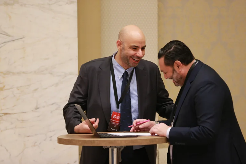 Delegates reviewing papers at a standing table at GIF Georgia 2025.