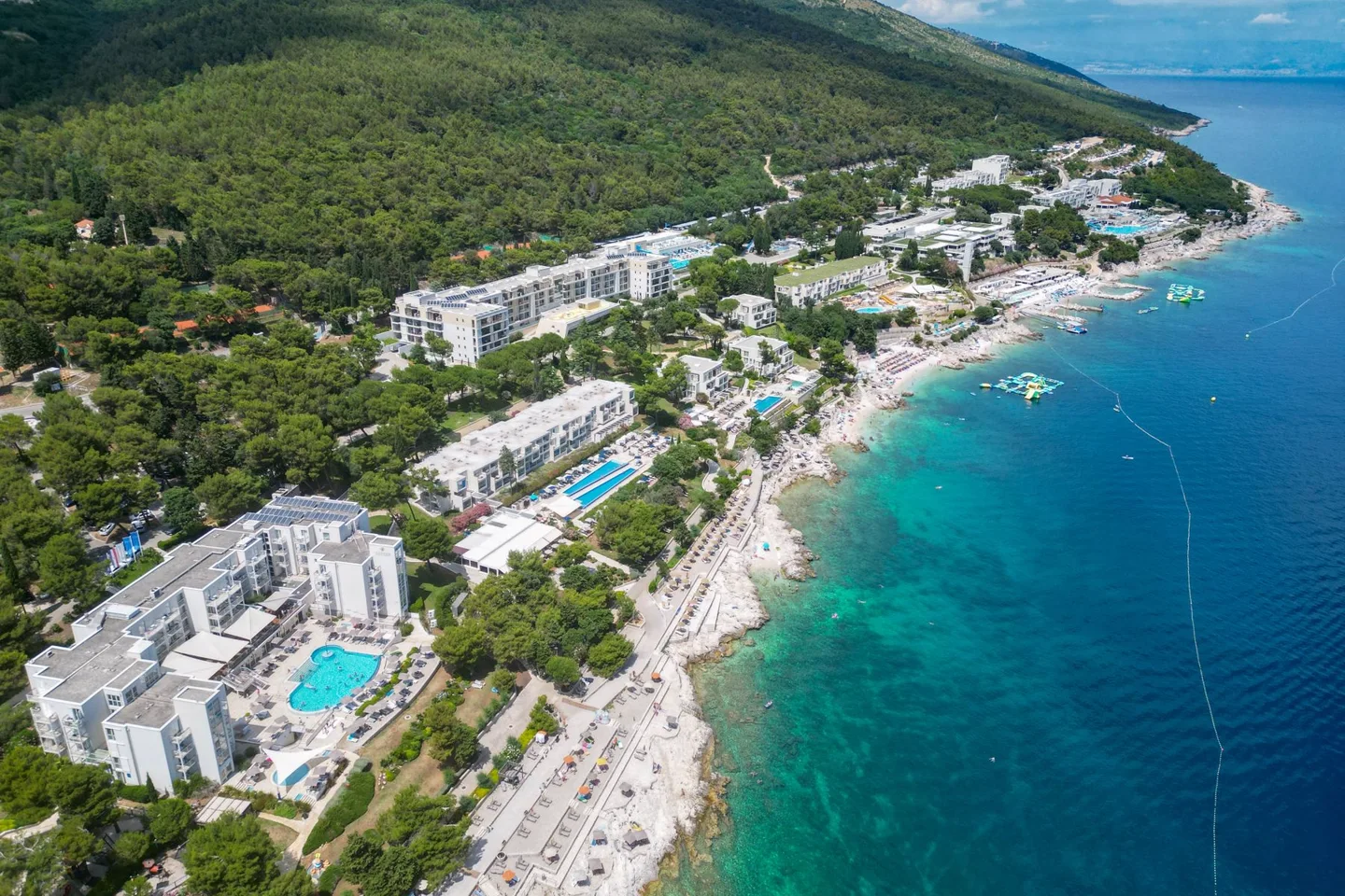 Aerial view of a coastal resort beside turquoise water.