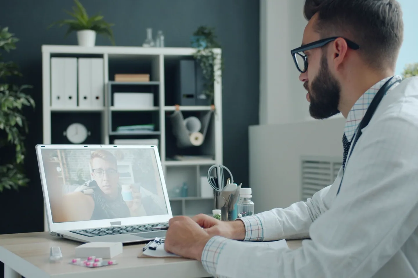 Doctor conducting a remote consultation on a laptop.